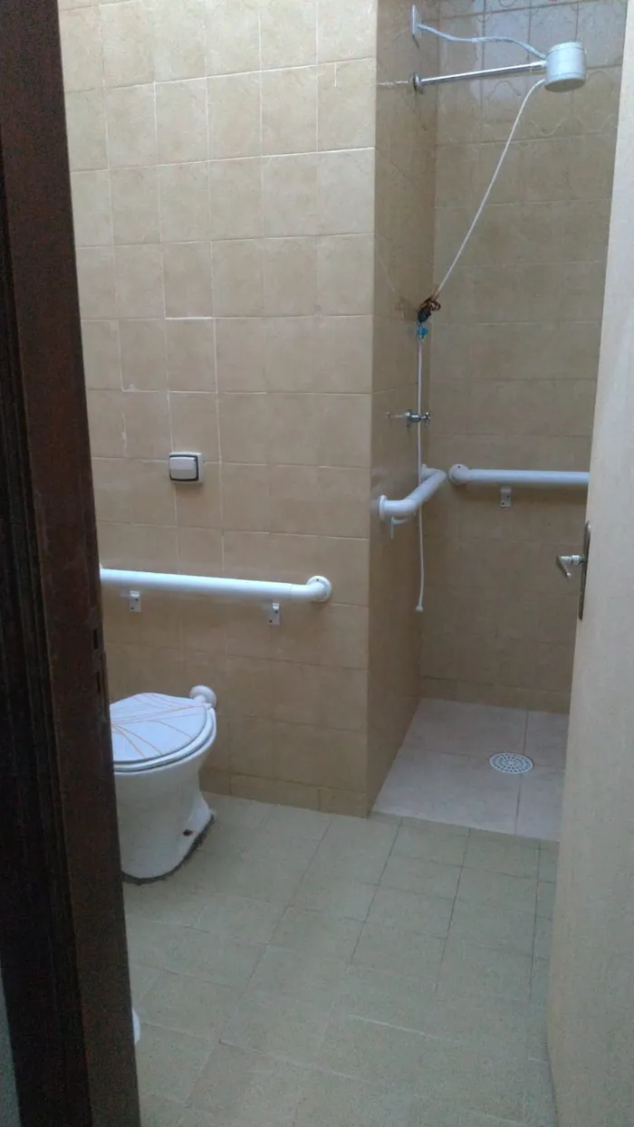 Banheiro totalmente adaptado para idosos com barras de apoio — segurança fundamental em casas de repouso