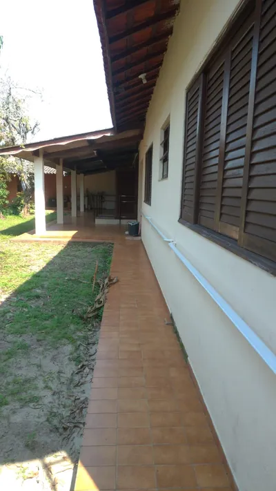 Corredor externo do residencial com jardim ao fundo — espaço amplo e arejado