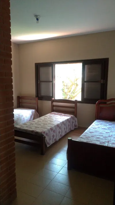 Quarto triplo arejado com camas de madeira — dormitório